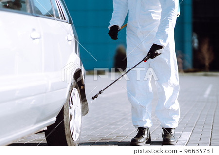 Man in protective suit washing and disinfection car wheels, to preventing the spread of the epidemic Man in protective suit washing and disinfection car wheels, to preventing the spread of the epidemic 96635731