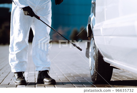 Man in protective suit washing and disinfection car wheels, to preventing the spread of the epidemic Man in protective suit washing and disinfection car wheels, to preventing the spread of the epidemic 96635732