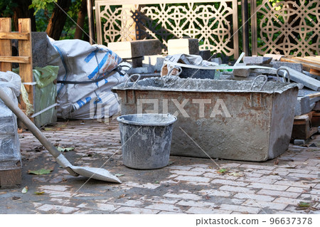 Cement, shovel and cement tub in construction site. Constuction details. Construction site 96637378