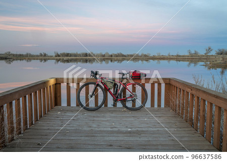 gravel touring bike at a lake shore at dusk 96637586
