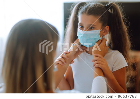 Mother and daughter use a protective mask against infectious diseases and flu. COVID-19 quarantine. 96637768