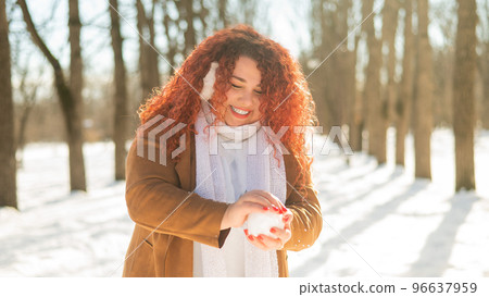 Fat caucasian woman playing snowballs in the park.  96637959