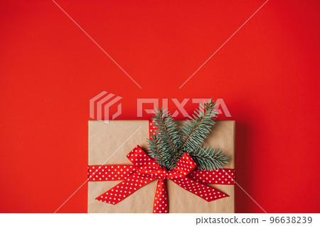 One Red luxury New Year gift box on red background. Christmas gift, Happy New Year 2023. Christmas background with craft paper gift box. One Red luxury New Year gift box on red background. Christmas gift, Happy New Year 2023. Christmas background with craft paper gift box. 96638239
