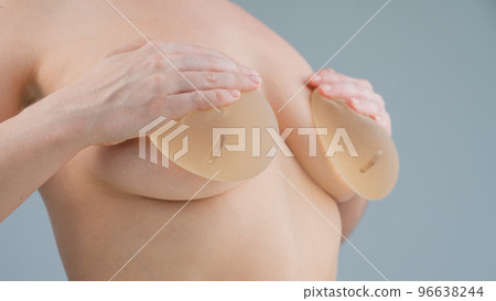 Caucasian naked woman trying on silicone breast Stock Photo