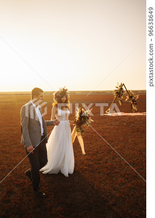 young and beautiful bride and groom enjoy each other. Wedding day in boho style. Warm summertime. young and beautiful bride and groom enjoy each other. Wedding day in boho style. Warm summertime. 96638649