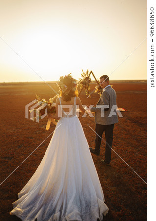 young and beautiful bride and groom enjoy each other. Wedding day in boho style. Warm summertime. young and beautiful bride and groom enjoy each other. Wedding day in boho style. Warm summertime. 96638650