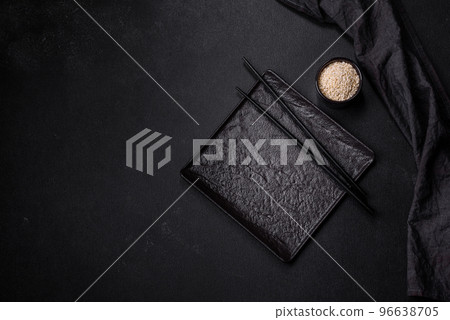 Empty plate with wooden sticks for Asian food on a dark concrete background 96638705