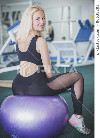 Beautiful blonde in leggings sits on a fitball 96639293