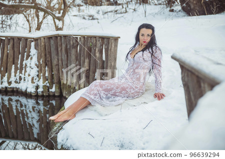 Attractive woman lying near the font in a white dress 96639294
