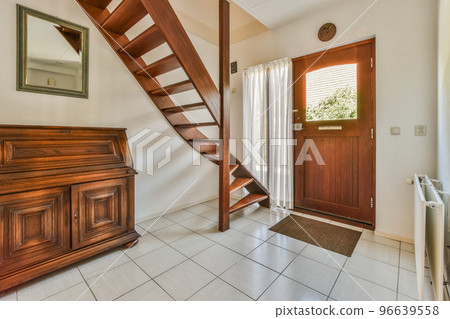 White hallway with wooden stairway leading to second floor of modern luxury apartment with minimalist interior design White hallway with wooden stairway leading to second floor of modern luxury apartment with minimalist interior design 96639558