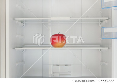 Red ripe apple on the shelf in the fridge. Health starvation, lose weight. Raw diet, starving concept. Red ripe apple on the shelf in the fridge. Health starvation, lose weight. Raw diet, starving concept. 96639822