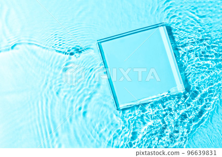Product presentation background. Mockup glass pedestal or glass stage lying in transparent blue water with splashes. Top view, copy space. 96639831