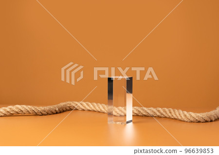Transparent glass podium and rope on a yellow backdrop. Crystal stage for fashion showcase, product presentation and advertisement. Front view, copy space. 96639853