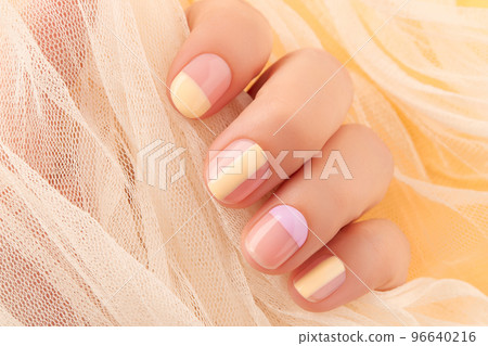 Beautiful females hand with manicure on yellow background. Trendy minimal spring summer nail design 96640216