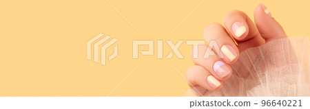 Beautiful females hand with manicure on yellow background. Trendy minimal spring summer nail design Beautiful females hand with manicure on yellow background. Trendy minimal spring summer nail design 96640221