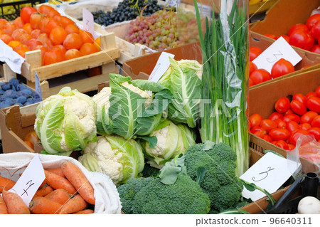 Vegetables are sold in mediterranean farmers fair. Healthy local food market. Broccoli, cauliflower, tomatoes, green onions, carrots, persimmon, grapes, plums. 96640311