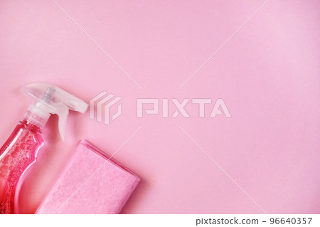 Detergents in spray. Cleaning accessories. Top view of pink cleaning supplies on pink background. Close up. 96640357