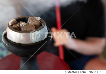 Shisha hookah with red hot coals and smoker on background 96641149