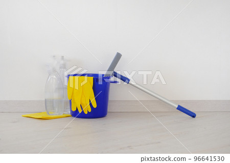Cleaning concept. Bucket with washing fluids, rubber protective glove and blue mop. Cleaning concept. Bucket with washing fluids, rubber protective glove and blue mop. 96641530