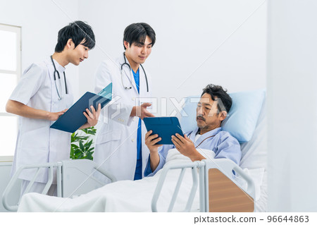 A doctor explaining a medical condition to a patient in a hospital room A doctor explaining a medical condition to a patient in a hospital room 96644863