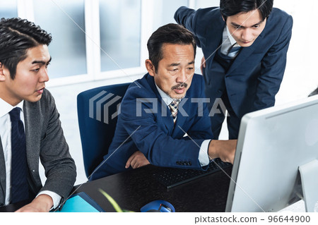 商人一邊看電腦屏幕一邊開會 96644900