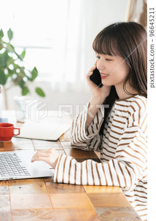 在家工作時打電話的年輕女性 96645211