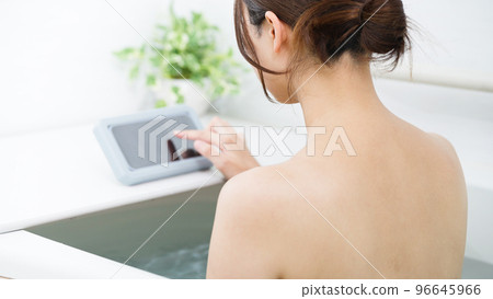 A woman using a smartphone in the bath A woman using a smartphone in the bath 96645966