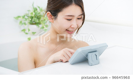 一個女人在洗澡時使用智能手機 一個女人在洗澡時使用智能手機 96645968