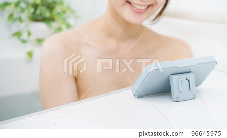 一個女人在洗澡時使用智能手機 96645975