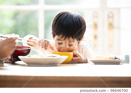 一個可愛的蹣跚學步的孩子用力吃米飯的特寫 96646700