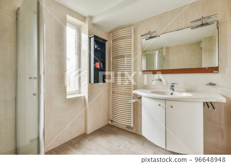 Glass partition between shower tap and wall hung toilet in modern restroom at home 96648948