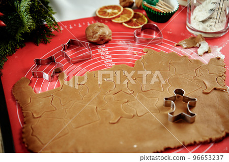 raw rolled dough for ginger cookies with cutter in shape of man. Traditional sweets for winter holidays 96653237
