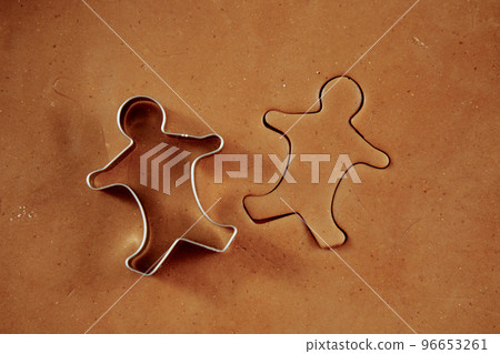 Raw rolled dough for ginger cookies with cutter in shape of man. Traditional sweets for winter holidays 96653261