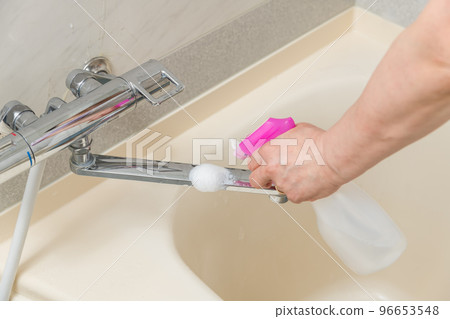 [Middle housewife cleaning the bath with a spray faucet] 96653548