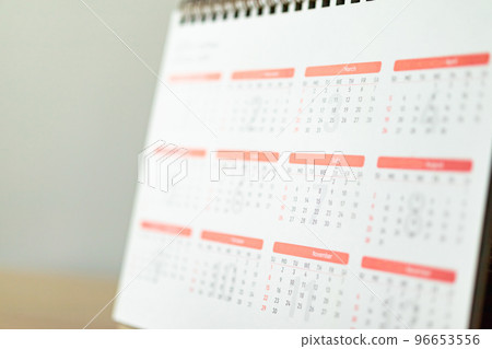 Calendar page close up on wood table with white wall background business planning appointment meeting concept Calendar page close up on wood table with white wall background business planning appointment meeting concept 96653556