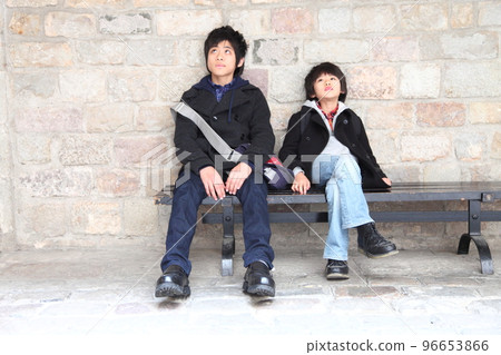 Brothers sitting on a bench and looking up 96653866