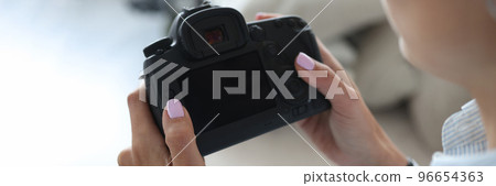 Woman photographer go through pics on camera backstage after photoshot Woman photographer go through pics on camera backstage after photoshot 96654363