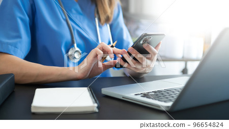 Medical technology concept. Doctor working with mobile phone and stethoscope in modern office Medical technology concept. Doctor working with mobile phone and stethoscope in modern office 96654824