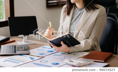 businesswoman hand working with new modern computer and writing on the notepad strategy diagram as concept morning light. businesswoman hand working with new modern computer and writing on the notepad strategy diagram as concept morning light. 96654825