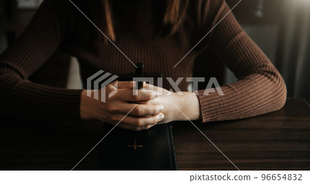 Woman praying on holy bible in the morning.Woman hand with Bible praying. Christian life crisis prayer Woman praying on holy bible in the morning.Woman hand with Bible praying. Christian life crisis prayer 96654832