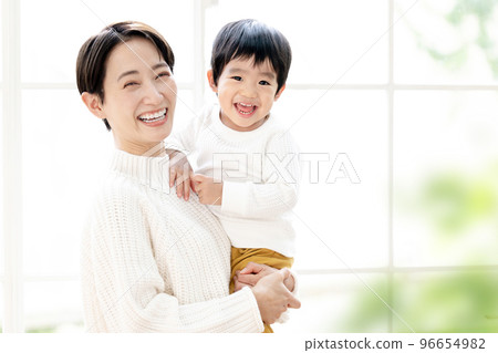 一張可愛的畫像,畫中一位母親和一個蹣跚學步的孩子微笑著擁抱,看著鏡頭 一張可愛的畫像,畫中一位母親和一個蹣跚學步的孩子微笑著擁抱,看著鏡頭 96654982