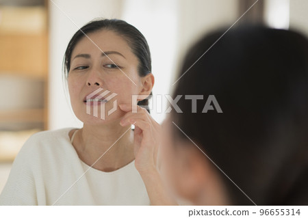 Image of a middle-aged woman who suffers from aging skin Image of a middle-aged woman who suffers from aging skin 96655314