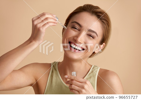 Woman Applying Serum on Face. Woman Applying Essential Oil On Facial Skin Woman Applying Serum on Face. Woman Applying Essential Oil On Facial Skin 96655727
