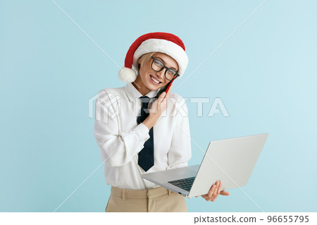 Happy Christmas Businesswoman Answering Call. Woman in Santa Hat Holding Laptop 96655795