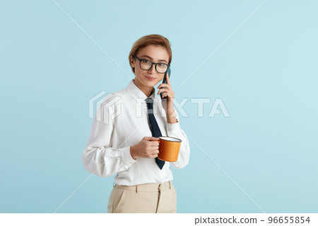 Busy Businesswoman Holding Coffee. Portrait of Woman in Glasses Talking Mobile 96655854