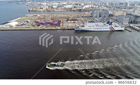 A fishing boat sailing with the Hakata Port ferry in the background 96656632