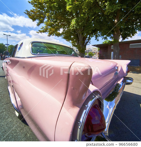 Wide angle view of the tail fin of a classic American road cruiser with light pink paint scheme Wide angle view of the tail fin of a classic American road cruiser with light pink paint scheme 96656680