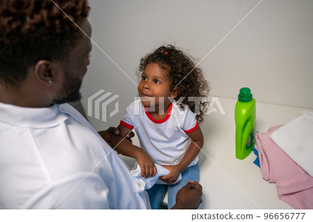 Kid and her dad at the launderette 96656777