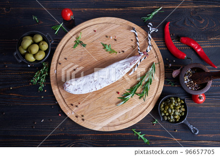 Spanish fuet salami sausageon wooden cutting board at domestic kitchen 96657705