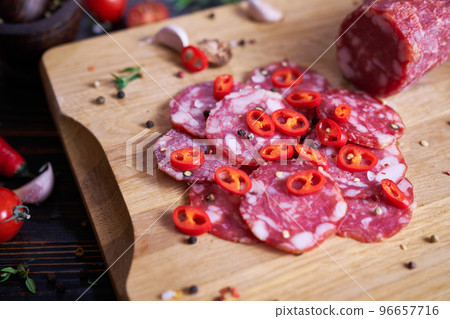 Traditional salami sausage on wooden cutting board with spices 96657716